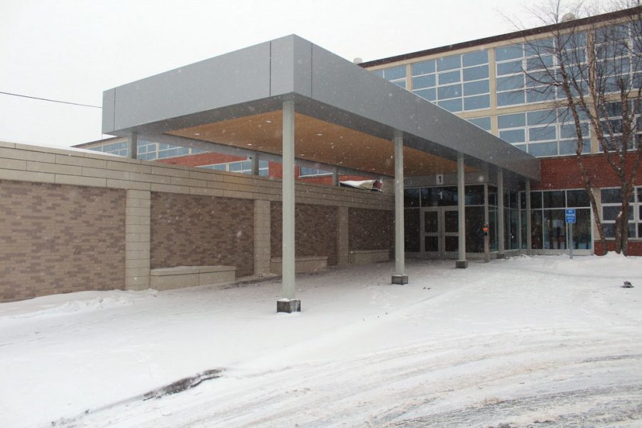 Snow falls in front of the new high school entrance Dec. 8. Winter break is now shorter than in previous years with students getting back to school Jan. 2.