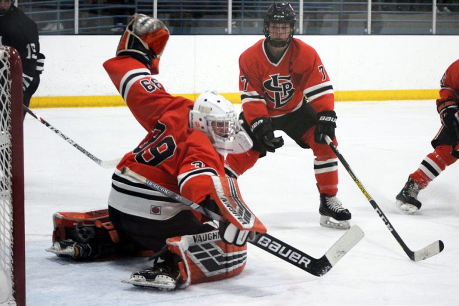 Seniors Will Pinney and Jacob Young work to stop a shot against Minneapolis Dec. 10. Pinney has a save percentage of .887 in the 2019-2020 season, according to the Star Tribune.