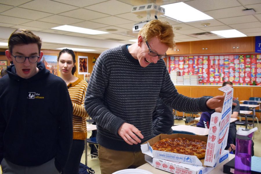 Senior Patrick Djerf smiles as he opens the pizza box during a pizza party in his history class. Djerf won this celebration by being on time 50 days in a row, a challenge that was set between him and his history teacher in October.
