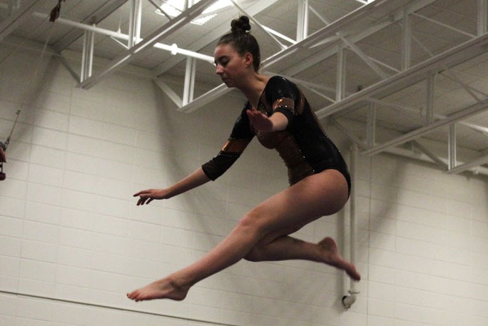 Freshman Ella Wasvick performs her beam routine Jan. 28 at Central Community Center. The gymnastics team lost their meet against Bloomington with a score of 124.8.