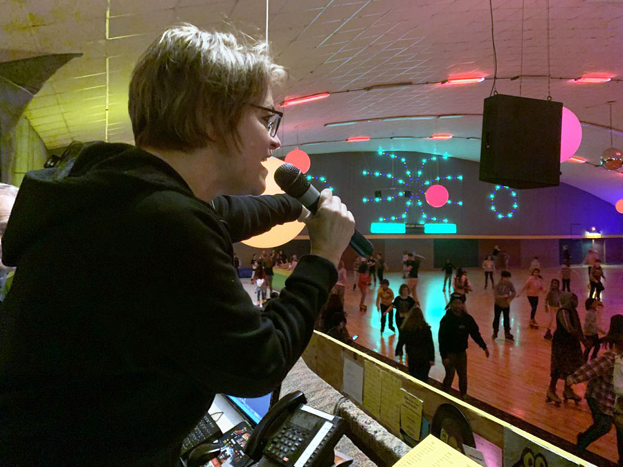 Adviser Shari Fox directs roller skaters to guess the language of the song she plays Jan. 30. Fox has planned international skate night for the last 13 years in an effort to allow middle schoolers to learn about the language and teachers they will have  the following year.