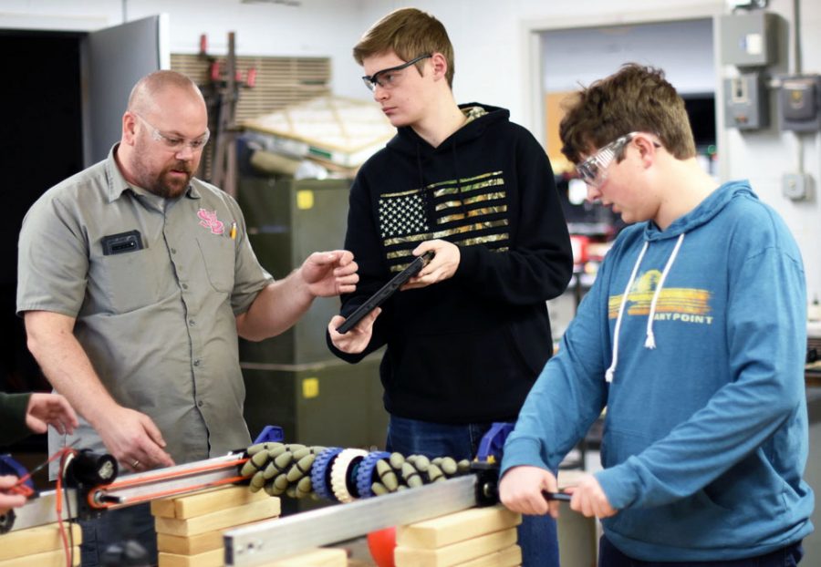 Robotics adviser Trevor Paulson works with junior Nick Perszyk during the teams meeting Feb. 10. According to Paulson, the team does not have a class during school hours to work so it has to stay after school. 