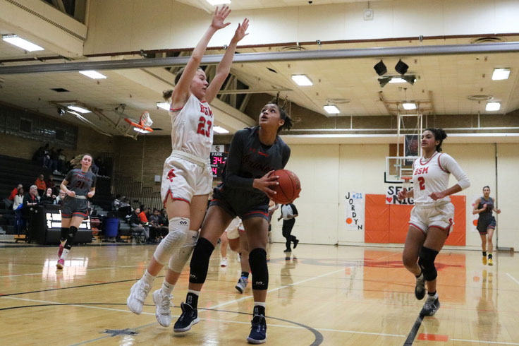 Junior Raegan Alexander takes a shot at the basket at the game against Benilde-St. Margarets Feb. 18. Alexander scored her 1,000th point at the start of the game. 