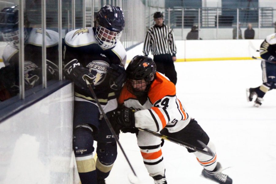 Senior Bobby Doss checks Chanhassen player Parker Thomas into the glass Feb. 6. Park currently holds a winning record of 14-8-0.