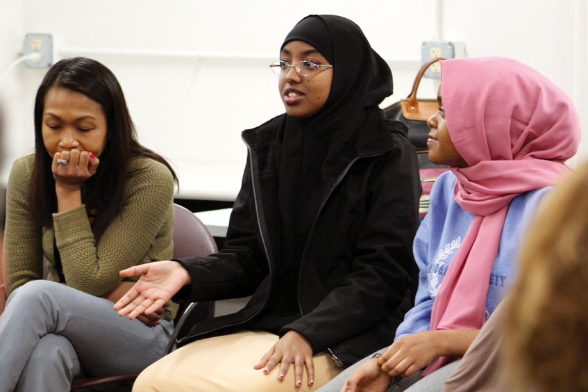 Director of assessment, evaluation and research Silvy Un Lafayette and junior Helen Tefera listen to junior Iqra Abdi share her opinion during the SOAR meeting Feb. 24. SOAR met with the superintendent and his administration to discuss issues surrounding race in the district as a whole.