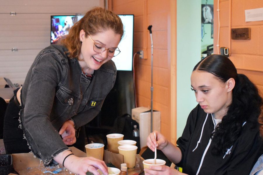 Brogan Berg, who makes environmentally-friendly bath products, assists junior Aaliyah Brown in making a bath bomb March 12. The Nest hosted an eco-friendly bath bomb making event as a part of a new series focusing on preserving the environment in the coming months.