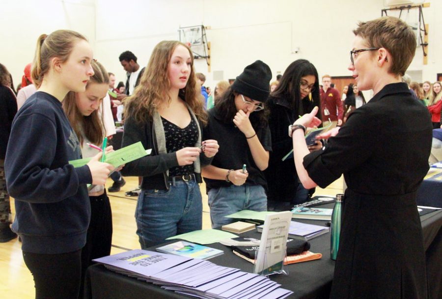 Freshmen Leila Campbell, Maren Wilsey, Cecelia Jensen, Elena Ortiz, and Alicia Narais talk with a representative from Aveda Institute Minneapolis at the college fair March 11. Students who are interested in receiving college credits as high schoolers can participate in PSEO.