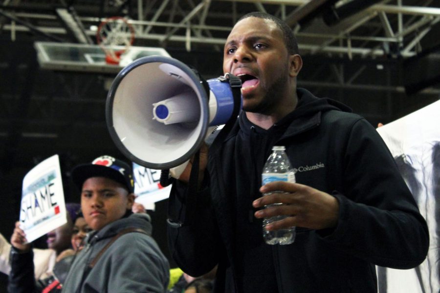A protestor leads chants over the megaphone. The cancellation announcement was made 8:40 p.m. after a 40 minute delay.