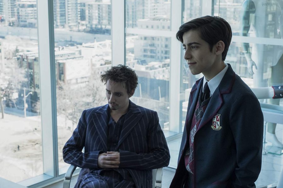 Fair use from Netflix. Klaus (Robert Sheehan) and Five (Aidan Gallagher) pose together for The Umbrella Academy. Klaus and Five both have super powers, with Klaus being about to see the dead and Five being able to time travel.