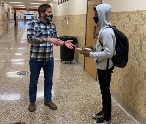 Science teacher Patrick Hartman helps a student in the hallway. Helping a student in the hallway during freshman orientation was one of the challenges featured in Employee Relief.