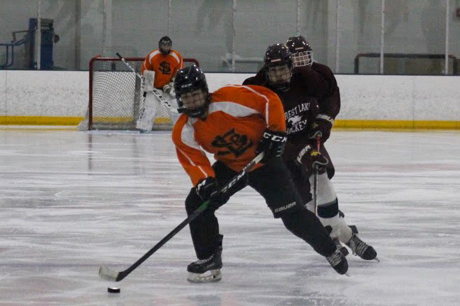 Sophomore Cole Taylor keeps the puck in position as he attempts to score a goal against Forest Lake. Park lost 5-3 against Forest Lake Nov. 10.