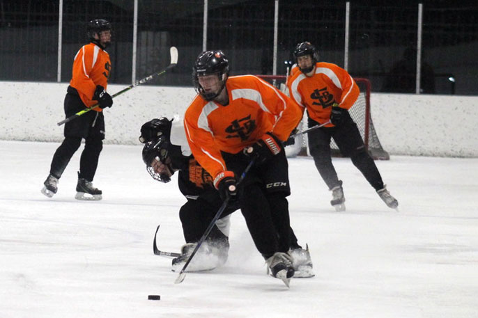 Senior Davis Bye protects the puck from Osseo’s defenders Nov. 12. Governor Tim Walz new restrictions on high school sports have delayed them for four weeks.