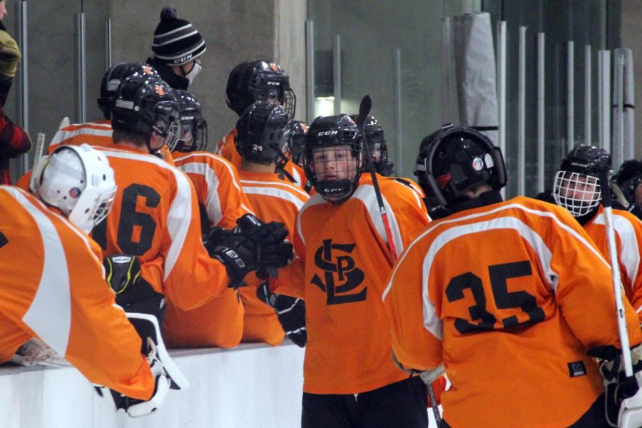 Junior Ben Farley high-fives his teammates after a goal was scored Nov. 12. Boys’ hockey is one of many sports that has been down players due to COVID-19 exposure.