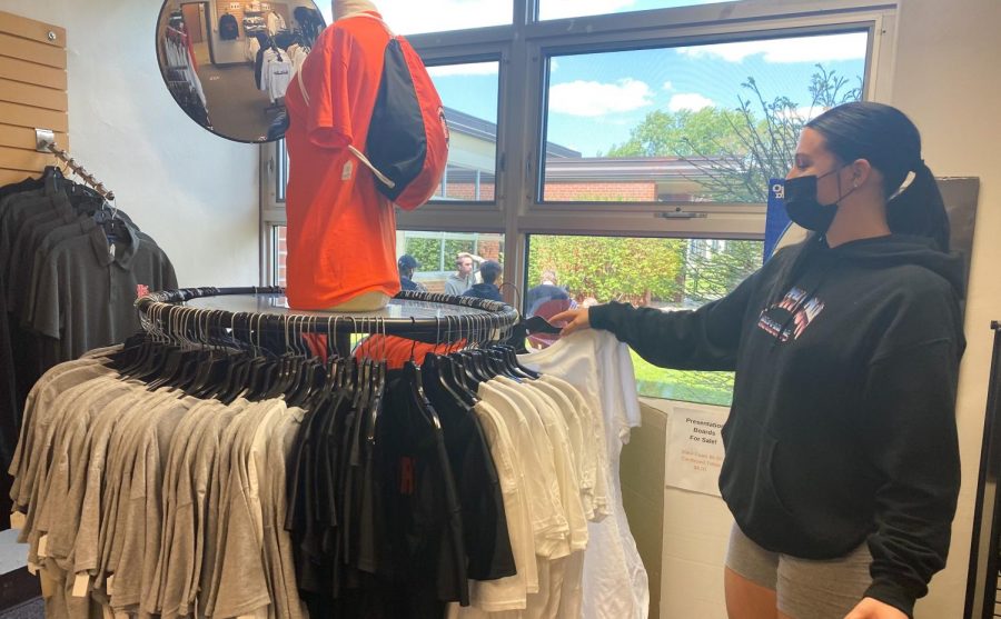 Senior Olivia Lainsbury re-stocks racks at the Storiole May 21. The Storiole plans on giving each senior a free class t-shirt.