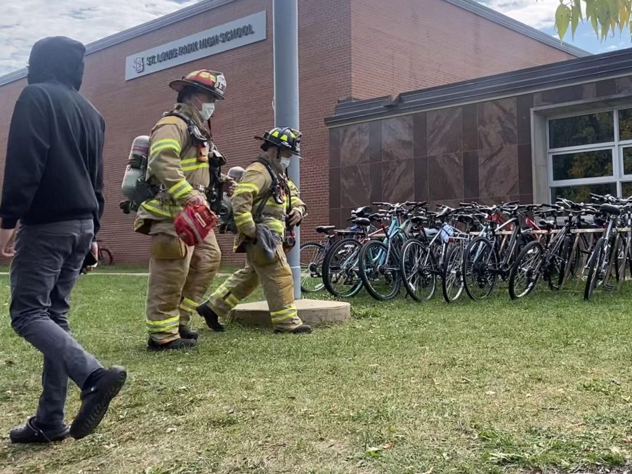 Firefighters+walk+to+investigate+the+situation+Sept.+30.+Student+were+evacuated+and+stayed+outside+during+the+lunch+period+to+ensure+safety+within+the+building.