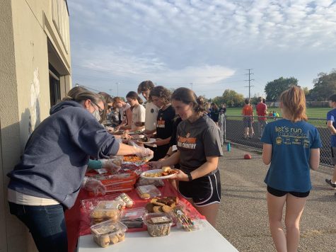 Junior Auden Whitlow gets food during a cross country pasta party Oct. 11. The team gathered in preparation for the Brookside Invitational which took place Oct. 12.