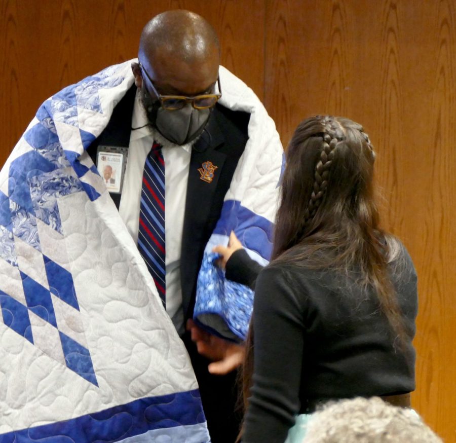 Superintendent Astein Osei receives a quilt alongside fellow school board members Oct. 26. The Land of Acknowledgment meeting was held in room C350.