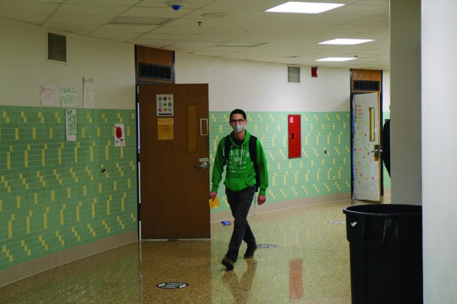 Senior Paris Lim walks down the hall with a pass Nov. 3. The Echo Editorial Board believes administration should collaborate with students to develop a new policy so they can work in the hallway as needed. 