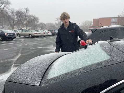After a winter storm, senior Evan Rosald brushes off a car Dec. 10. According to Superintendent Astein Osei, two extra days will be added to winter break in order to alleviate student and staff stress.  