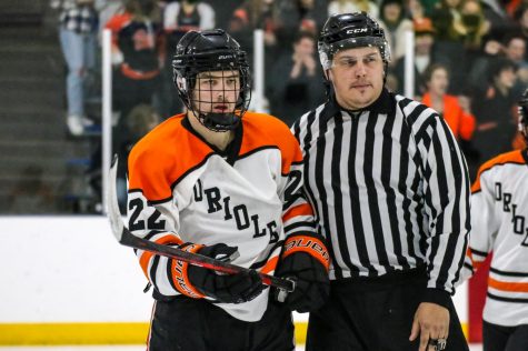 After a brawl in the second period senior Captain Ben Olson gets escorted to the penalty box by a referee. Olson was not suspended for the next game at Waconia. 