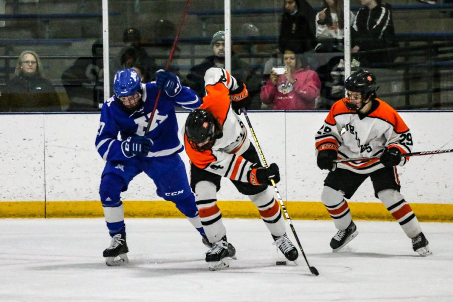 Sophomore forward Griffin Krone defends the puck from a Minnetonka defender Dec. 9. Krone had one assist during the game against Minnetonka. 