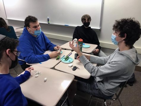 Sophomores Asher Shertok, Jonah Kaufman, Isaac Israel and junior Eli Kaufman make dreidels at the Dec. 2 JSU meeting. Club members also ate snacks and learned about Hanukkah during the meeting.