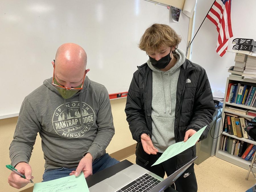 Senior Sam Steffy meets with physics teacher Daniel Ruzek about a question on a test. Students are able to take a pass instead of a grade to reduce the negative impact a grade could have on their GPA.