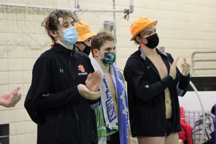 Boys swimming cheers on its teammates Jan. 12. The swimmers wear masks when they are out of the pool or waiting to swim in an event.