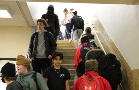 Junior Stefano Giovannelli walks down the stairs maskless March 10. On March 9, the School Board accepted a revision to policy 808, causing masking at schools to be optional.