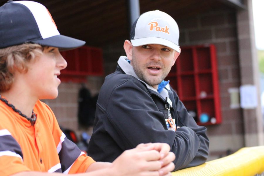 Junior Elijah Puchner and Athletic Trainer Josh Broderson chat on the bench May 20. Park won against Benilde-St. Margarets 5-4.
