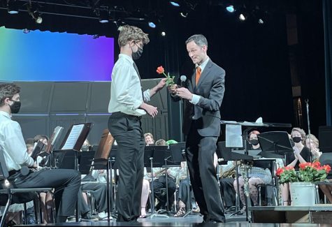 Onstage, senior Carlitos Anguita-Smith receives a rose from Band Director Steve Shmitz May 3. After the band concert, Shmitz handed out roses to recognize the achievements of the graduating seniors.