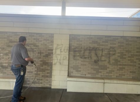 A park staff member works to clean off graffiti by the main entrance May 27. Two instances of vandalism happened at Park. 