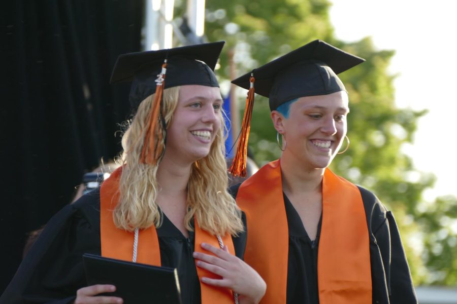 Seniors Molly Austad and Ellie Austad walk down the stage together June 7. The graduation ceremony started at 7 p.m.  