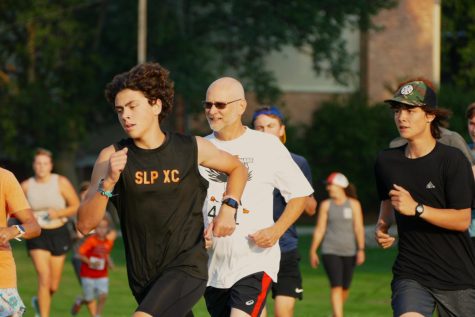 Sophomore Will Carpenter runs along St. Louis Park Cross Country supporters. The team ran two miles 6:30 p.m. at the St. Louis Park Middle School Sept. 24.