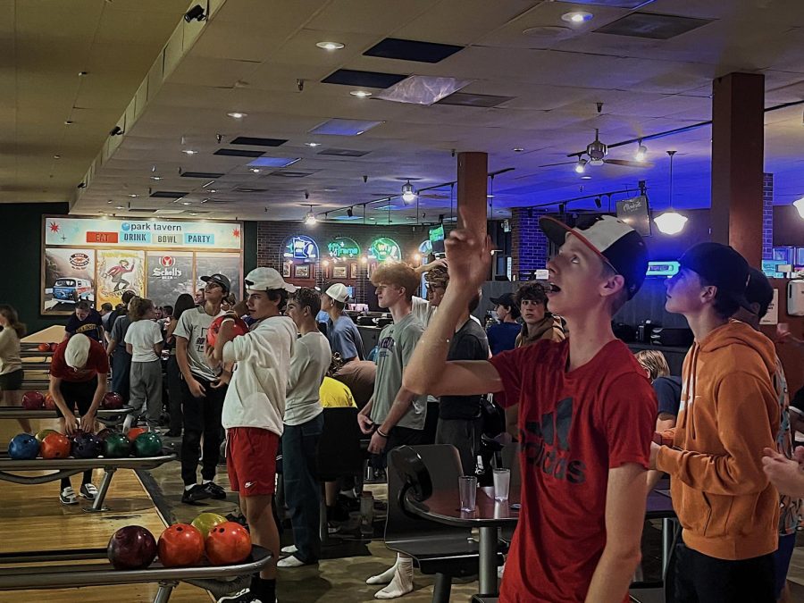 Sophomore Matthew Plant points in excitement after bowling a strike. Over 40 cross-country runners gathered at Park Tavern to bowl together for team building.
