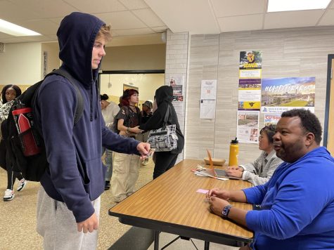 Senior Thomas Kniser is granted access to leave campus for lunch after showing his student ID to a teacher on Monday, Oct 10. New senior rules are much stricter than previous years.