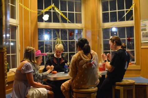 Participants gather around a table to paint pumpkins. The Depot hosted its Halloween party on Oct. 28.