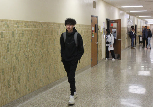 Junior Santiago Cabral walks down the hallway to biology Nov. 3. Fashion is a way for students to express themselves in school.