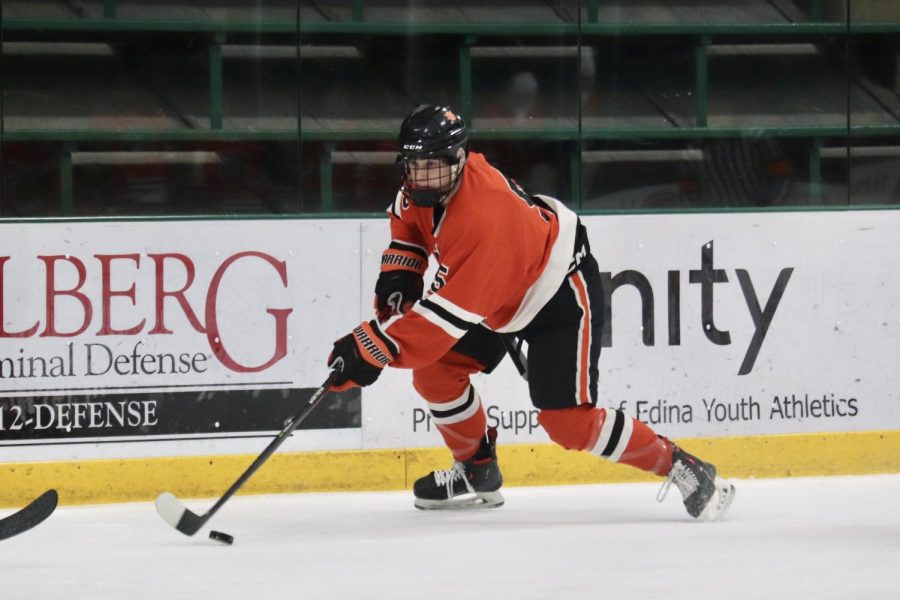 Sophomore Max Rider handles the puck as he skates up ice Dec. 15. Park played an equally offensive and defensive game in the Edina Holiday Classic. 