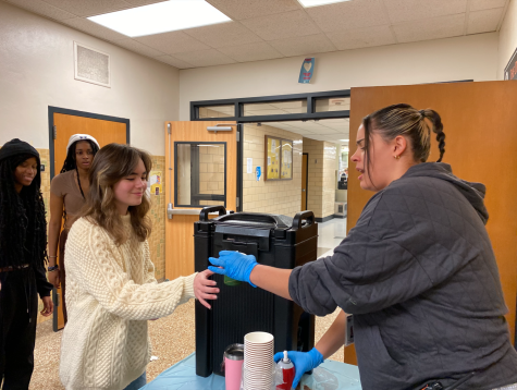 Ms. Dagen hands out hot chocolate to sophomore Chloe Lorentz. Student council organized for hot cocoa to be available to students during lunchtime.