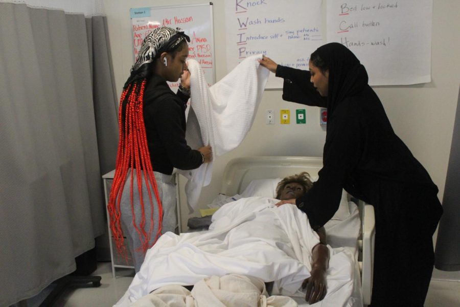 Junior Victoria Taylor and senior Amina Mohamed practice with a mannequin Jan. 23. Students work hands-on to prepare for the CNA certification test.