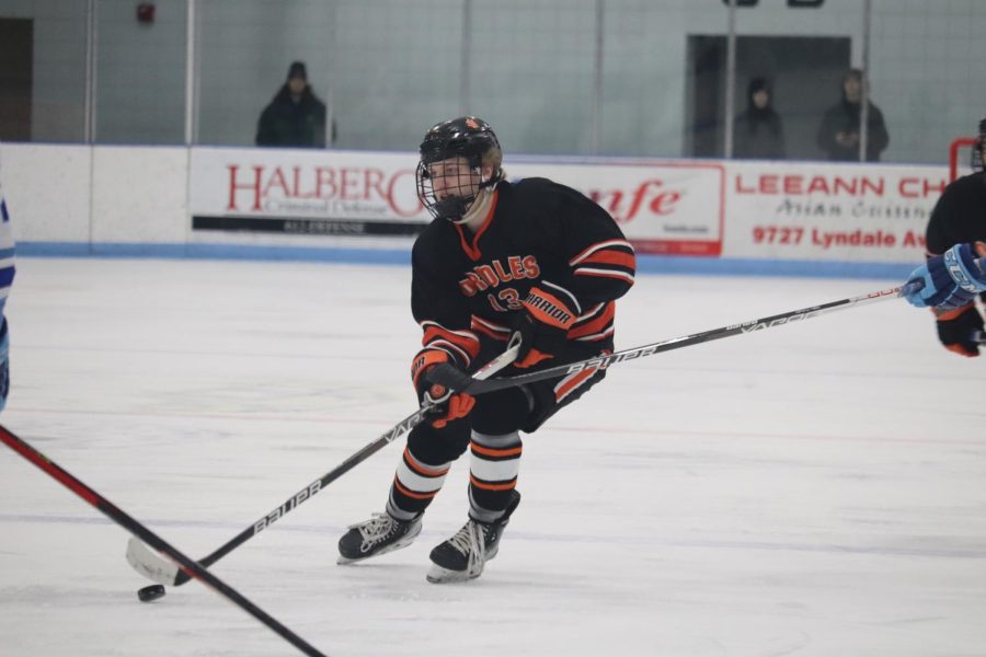 Sophomore Jack Betzer weaves through defenders with the puck. The Orioles won their fifth conference game against the Jaguars Jan. 10. 