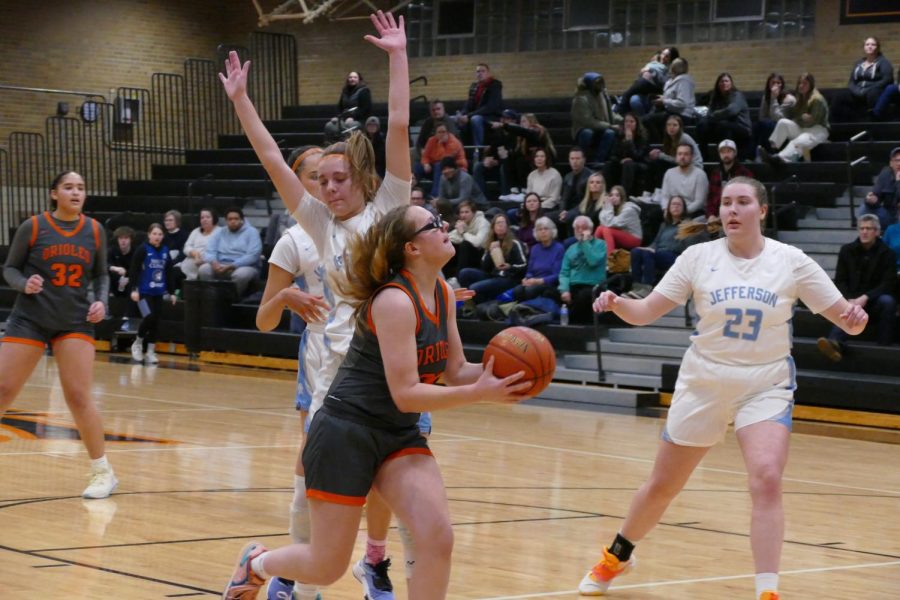 Junior Evelyn Schmitz gets ready for a layup, passing Jefferson defenders Feb. 24. The girls’ next game is against Cooper, in the first round of sections March 1.