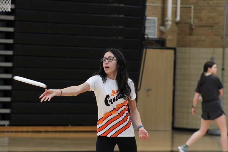 Sophomore Ximena Gomez Rodriguez practices short throws as a warmup March 17. The Crush ultimate team has to practice indoors due to the late snow.