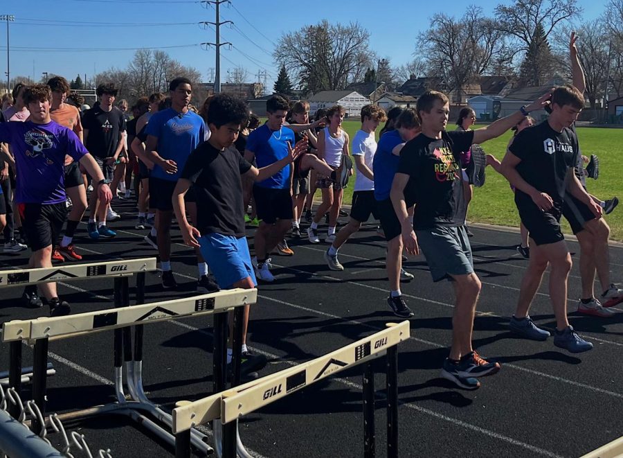 Senior Denly Lindeman leads the track team during pre-practice stretching April 13. The team was successful in rasing money for the program through fundraising efforts.