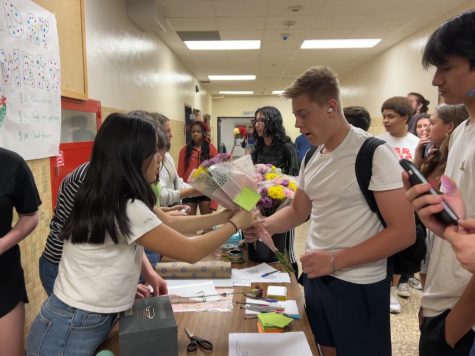 Sophomore Ruby Viot sells flowers to Evan Cormier April 14. During lunch, AP European History students fundraised for the trip by selling flowers.