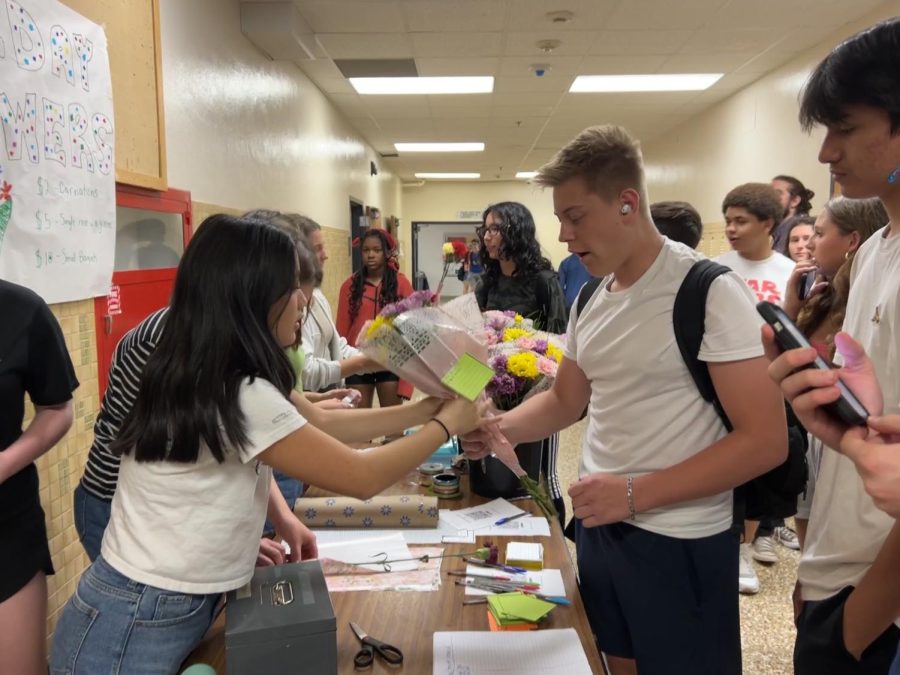 Sophomore+Ruby+Viot+sells+flowers+to+Evan+Cormier+April+14.+During+lunch%2C+AP+European+History+students+fundraised+for+the+trip+by+selling+flowers.