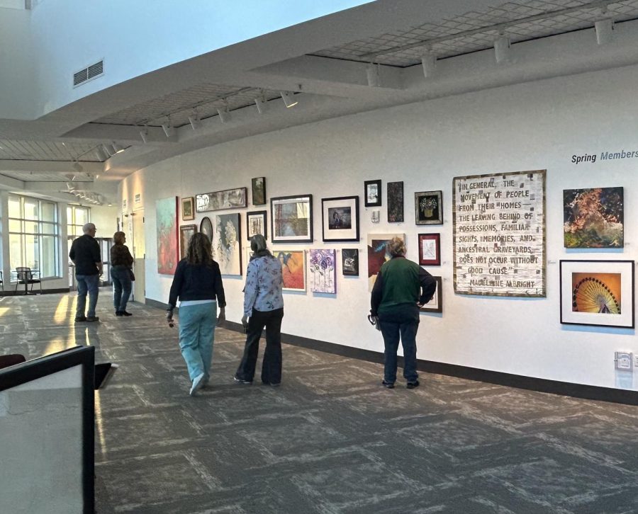 Locals and artists observe art from the Spring Members Exhibition April 8. Many browsed the local art gallery on display at the Hopkins Center of the Arts.