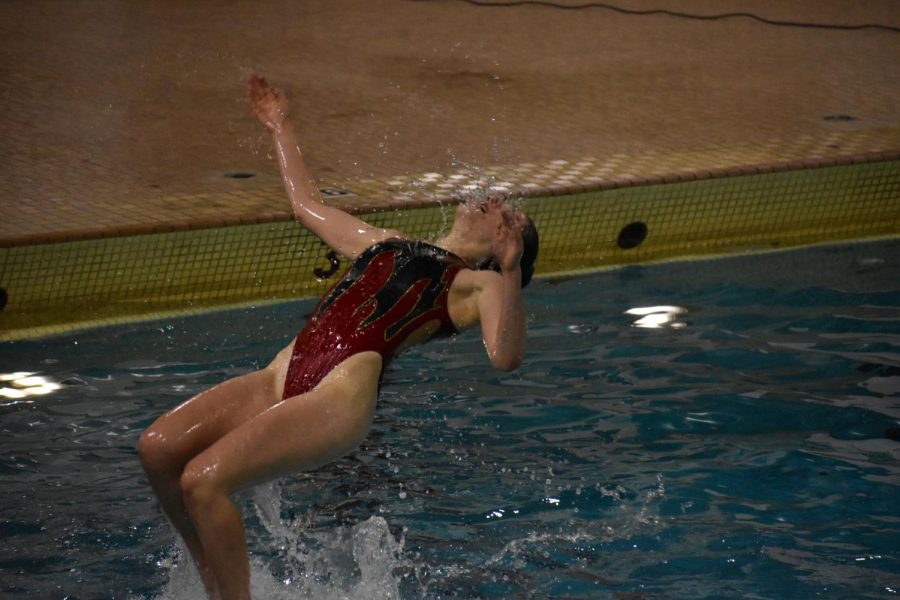 Freshman Kaylee Crump performs a backflip during a group routine May 17. The season for synchronized swimming commemoratively ended with the event.