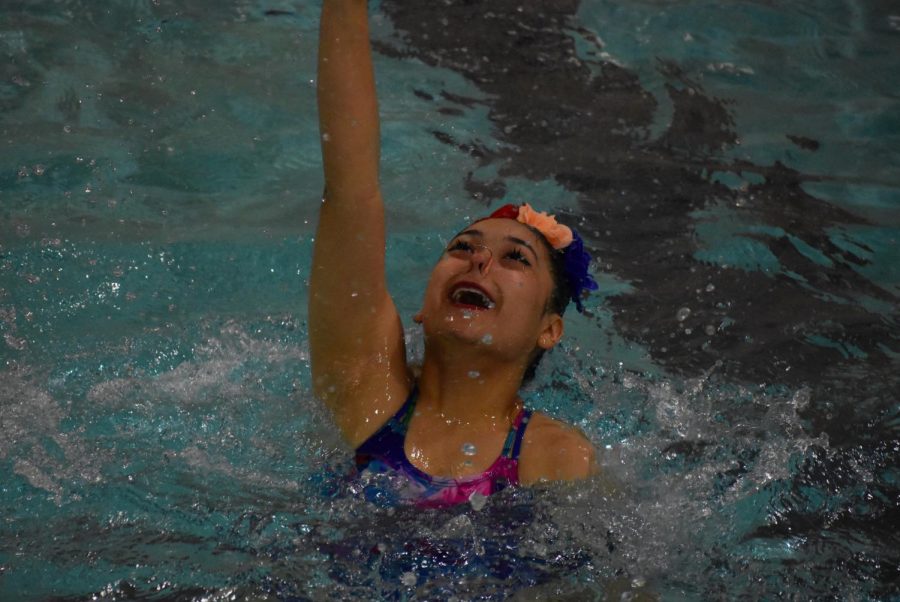 Junior Katherine Velez reaches up during her team routine on May 17. The middle school and high school synchronized swimmers performed for parents and fans on Wednesday.